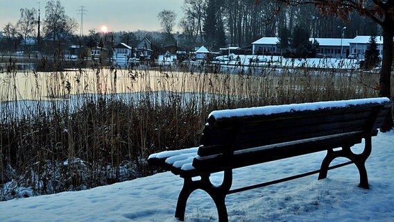 Verschneite Parkbank an einem See © NDR Foto: Andrea Werner aus Waren