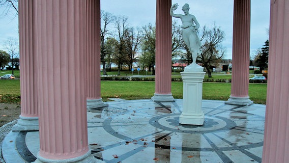 Frauenstatue steht auf einem feuchten Steinboden in einem Tempel mit rosa Säulen. © NDR Foto: Wilfried Baganz aus Neustrelitz