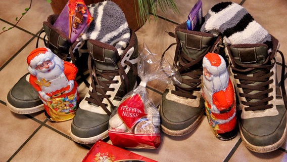 Zwei Paar Schuhe sind mit Socken und Schoko-Weihnachtsmännern gefüllt. © NDR Foto: Eckhard Wolfgramm aus Salow