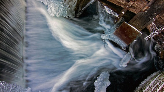 Halbgefrorenes Wehr einer Wassermühle aus der Draufsicht in Langzeitbelichtung © NDR Foto: Brita Hilgendorf aus Teterow