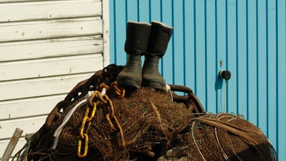 Auf einem großen Haufen von Tauen steht ein paar Stiefel. © NDR Foto: Sylke Engelhardt aus Stralsund