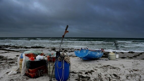 Boot und Fässer am Strand mit dunklem Himmel © NDR Foto: Robert Ott aus Vitte