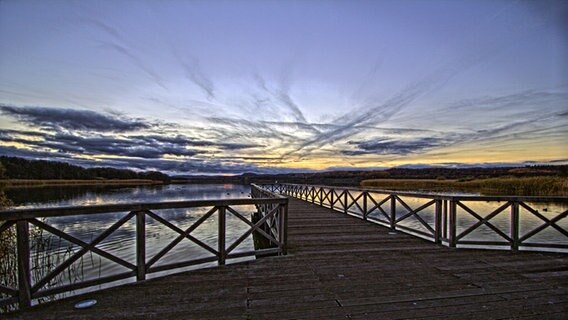 Seebrücke ragt in einen See und am Himmel sind aufgeregte Wolken zu sehen. © NDR Foto: Thomas Starkloff aus Sassnitz