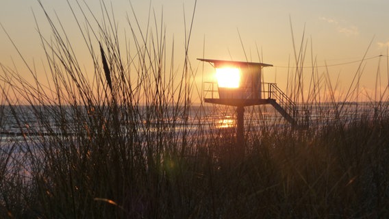 Ein DLRG-Wachturm am Strand von Bansins wird von der untergehenden Sonne angestrahlt. © NDR Foto: Gerhard Kothy aus Bansin