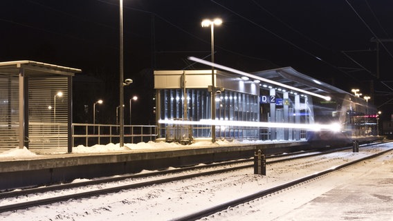 Zug fährt im verschneiten Bahnhof ein. © NDR Foto: Claudio Doering aus Greifswald