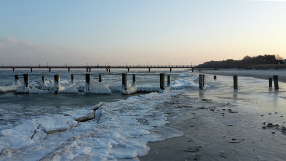 Ein vereister Fischerstrand mit einer Seebrücke im Hintergrund. © NDR Foto: Marion Schmidt aus Barth