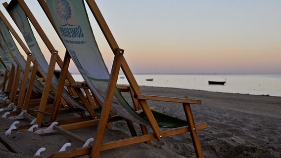 Leere Strandstühle am Strand bei Sonnenaufgang. © NDR Foto: Günter Kamp aus Greifswald