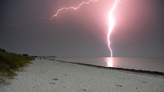Über einem Strand leuchtet ein Blitz auf. © NDR Foto: Robert Ott von der Insel Hiddensee