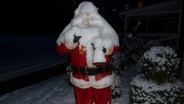 Ein Weihnachtsmann steht im Garten und ist mit Schnee übertdeckt © NDR Foto: Elke Wiehle aus Delmenhorst