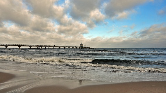 Blick auf die Seebrücke vom Strand aus. Der Himmel ist bewölkt, die Ostsee unruhig. © NDR Foto: Norbert Brandt aus Neubrandenburg