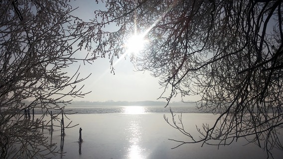 Die Sonne steht hoch über einem teilweise zugefrorenen See. © NDR Foto: Thomas Eichler aus Bad Kleinen