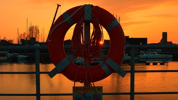 Sonnenaufgang durch einen Rettungsring am Wismarer Hafen. © NDR Foto: Markus Pentti aus Wismar