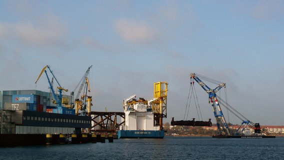 Ein Kran hebt ein großes Stahlgerüst über das Wasser im Hafen von Wismar. © NDR Foto: Helmut Kuzina aus Wismar