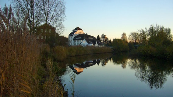 Ein Haus spiegelt sich im Wasser. © NDR Foto: Elke Wehmer aus Plate