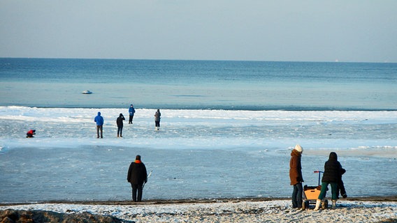 Menschen laufen über das Eis am Strand vom Schwarzen Busch auf Poel © NDR Foto: Hubertus Doberschütz von der Insel Poel