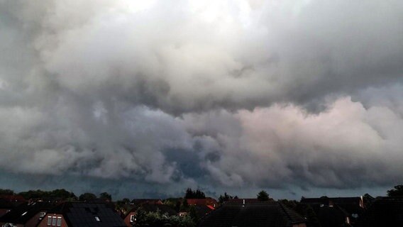 Bedrohliche Wolken ziehen über einer Siedlung auf. © NDR Foto: Walter Rodewald aus Peckatel