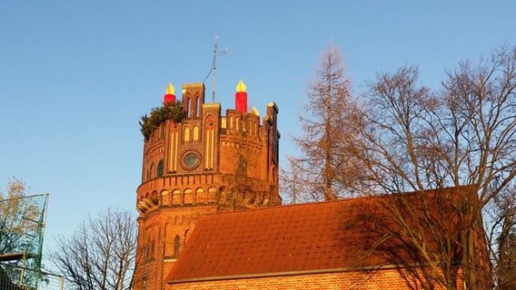 Kerzen stehen als Dekoration auf einem Wasserturm. © NDR Foto: Heiner Kley aus Schwerin