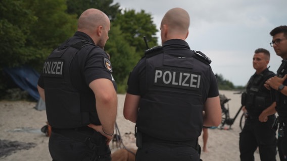 Polizisten kontrollieren am Strand Jugendliche © NDR 