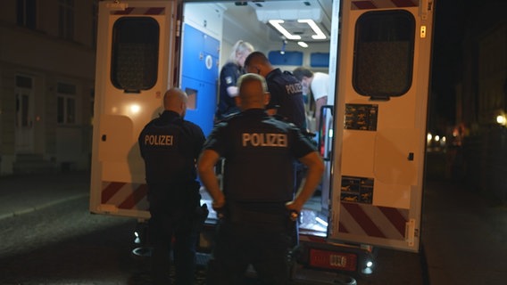 Polizisten stehen am Krankenwagen © NDR 