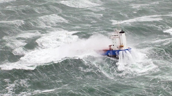Ein Schiff fährt bei einer Sturmflut über die Nordsee.  