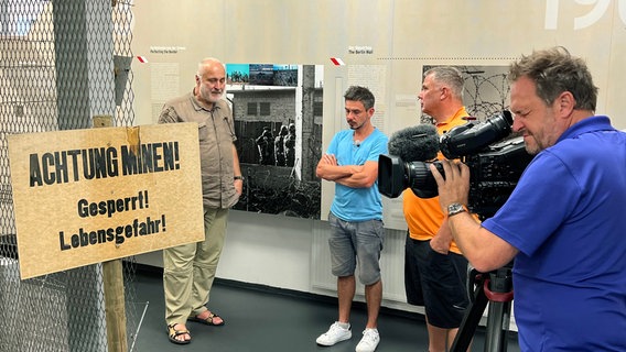 Im Grenzlandmuseum Eichsfeld bei Duderstadt tauchen Reporter Peter Jagla und Radenthusiast Thomas Kempernolte (mitte) ein in die deutsch-deutsche Geschichte. Georg Baumert erzählt von den Grenzanlagen der ehemaligen DDR. Im Grenzlandmuseum Eichsfeld bei Duderstadt tauchen Reporter Peter Jagla und Radenthusiast Thomas Kempernolte (mitte) ein in die deutsch-deutsche Geschichte. Georg Baumert erzählt von den Grenzanlagen der ehemaligen DDR. © NDR/Friederike Castenow