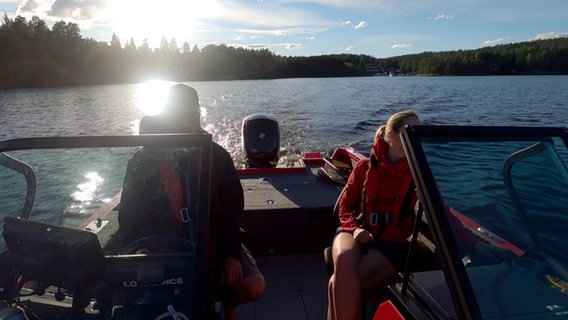 Eine Frau und ein Mann fahren mit einem Motorboot auf einem See. © NDR / Laura Knittel 