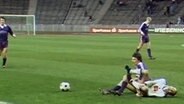 Zwei Fußballer stossen auf dem Feld zusammen  