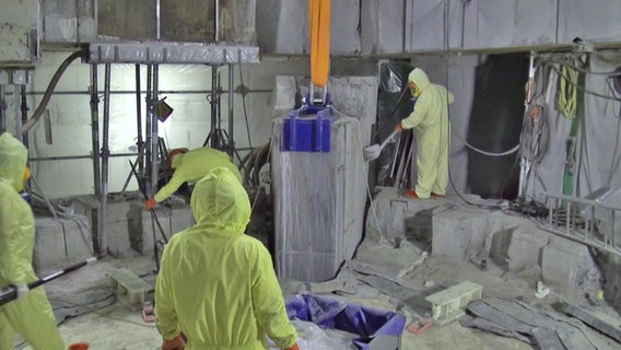 Arbeiter bauen ein AKW zurück. © Screenshot 