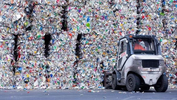 Ein Radlader vor zu Packen aufgestapeltem, sortiertem Plastikmüll. © picture alliance/dpa Foto: Rolf Vennenbernd