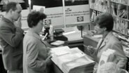 Frau bucht eine Reise im Reisebüro © Screenshot 