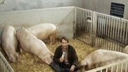 Ein Mann sitzt im Schweinestall © Screenshot 