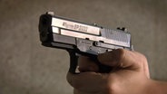 Eine Hand hält eine Pistole vom Typ 2022 der Firma SIG Sauer. © Screenshot 