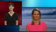 Eine Frau dolmetscht Anja Reschke in Gebärdensprache.  