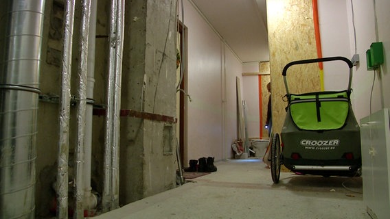 Ein Kinderwagen steht im Hausflur eines Hamburger Hochhauses, in dem Asbestfasern freigesetzt wurden. © NDR 