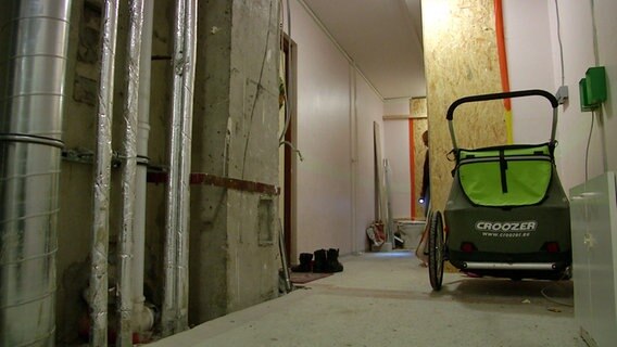 Ein Kinderwagen steht im Hausflur eines Hamburger Hochhauses, in dem Asbestfasern freigesetzt wurden. Ein Kinderwagen steht im Hausflur eines Hamburger Hochhauses, in dem Asbestfasern freigesetzt wurden. © NDR