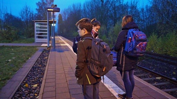 Jugendliche stehen an einem Bahnsteig und warten auf einen Zug. © NDR Foto: Screenshot