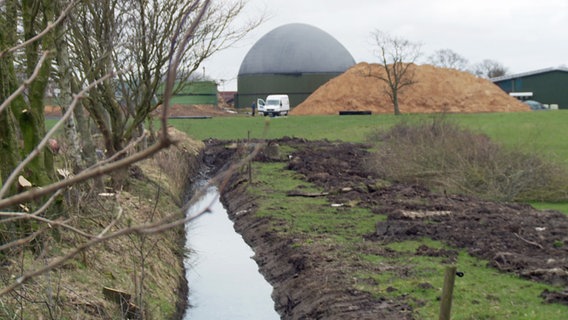 Biogasanlagen vor kleinem Bach.  