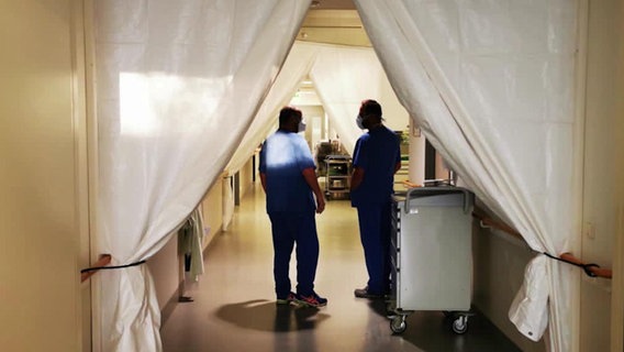 Zwei Pfleger stehen auf einer Intensivstation © NDR Foto: Screenshot