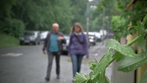 Zwei Menschen gehen auf einer Straße  