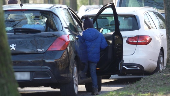 Ein Kind steigt in ein Auto  