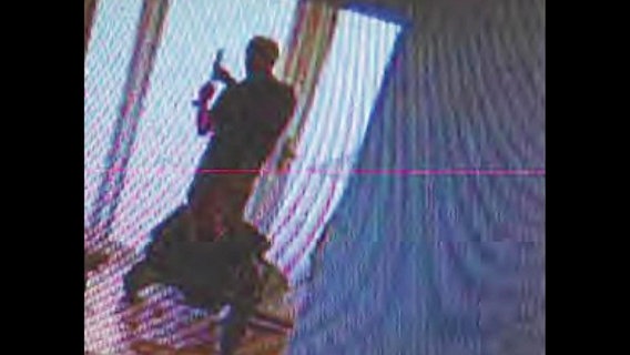 Am Tag der Tat sieht man auf Bildern der Überwachungskameras, dass Hartmut F. einen Schalldämpfer auf die Maschinenpistole schraubt. © Screenshot 