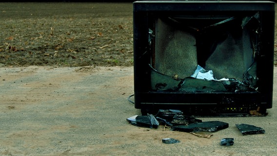 Ein defekter Röhrenfernseher steht auf einem Feldweg. © Photocase Foto: Kallejipp