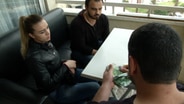 Der Schleuser Abu Suhaib bekommt von zwei Flüchtlingen ein Geldbündel. © NDR Foto: NDR