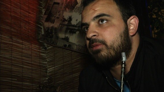 Rami sitzt mit einer Schischa in einem Restaurant. © NDR Foto: NDR