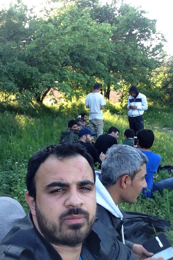 Rami und eine Gruppe von Männern sitzen auf einer Wiese. © NDR 