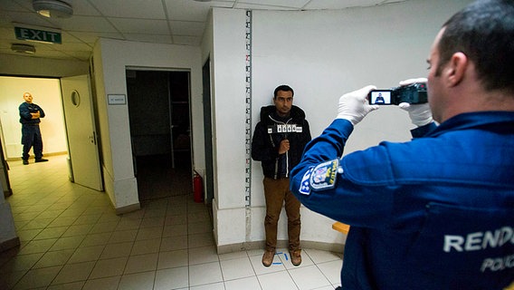 Ungarische Polizisten registrieren syrische Flüchtlinge, bevor diese in einem Auffanglager interniert werden. © dpa/picture-alliance Foto: Zoltan Balogh