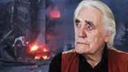 Thumbnail: Ein älterer Mann im rechten Bildbereich schaut auf ein brennendes Haus. © NDR Foto: Screenshot