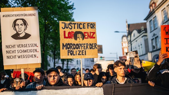 Demonstranten in Oldenburg halten Schilder hoch, die an Lorenz A. erinnern, der von einem Polizisten erschossen worden war. © picture alliance/Anadolu Foto: Hesham Elsherif