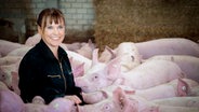 Gabriele Mörixmann zwischen Schweinen in ihrem Stall. © NDR 