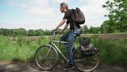 Ein Mann fährt mit seinem Rad auf einem Radweg. © NDR Foto: Screenshot